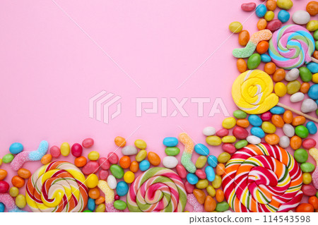 Colorful lollipops and different colored round candy on pink background Colorful lollipops and different colored round candy on pink background 114543598