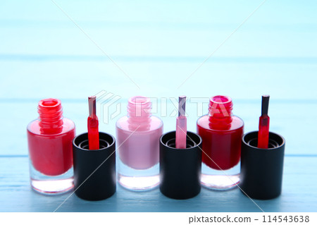 Group of pink nail polishes on blue background 114543638