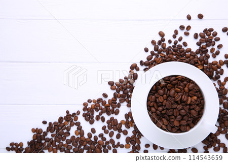 Coffee beans in cup on white wooden background. Coffee beans in cup on white wooden background. 114543659