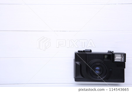Vintage camera on white wooden background. Old photo camera on background Vintage camera on white wooden background. Old photo camera on background 114543665