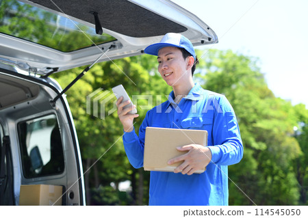 男性外送司機拿著行李，看著智慧型手機 114545050