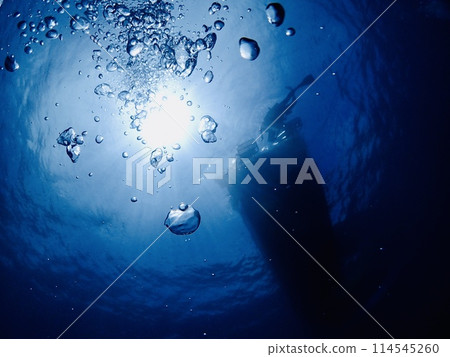 Sunshine, bubbles and the silhouette of a ship seen from underwater 114545260