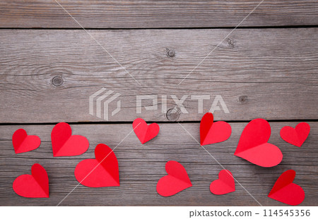 Paper red hearts on a grey background. 114545356