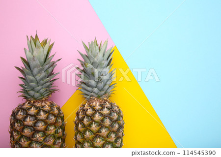 Two ripe pineapples on a colorful background 114545390