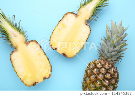 Pineapple and half of pineapple on a blue background Pineapple and half of pineapple on a blue background 114545392