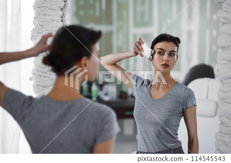 Facial skin care. A woman is doing a face massage using a massager that passes micro current. 114545543