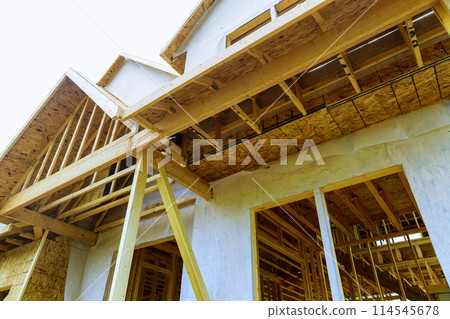 There is joist framework with plywood installed, gutter holders trim installed on soffit fascia house that is under construction There is joist framework with plywood installed, gutter holders trim installed on soffit fascia house that is under construction 114545678