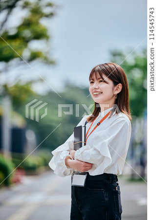 Smiling young woman holding a notebook Smiling young woman holding a notebook 114545743