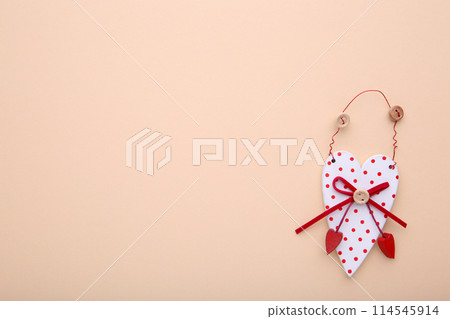 A wooden heart on a beige background. A wooden heart on a beige background. 114545914