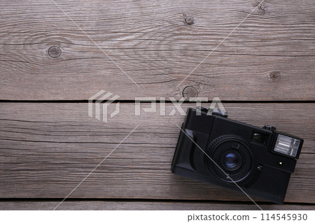 Vintage camera on grey wooden background. Old photo camera on grey background Vintage camera on grey wooden background. Old photo camera on grey background 114545930