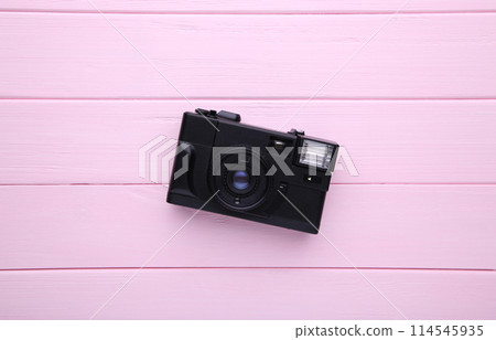 Vintage camera on pink wooden background. Old photo camera on background Vintage camera on pink wooden background. Old photo camera on background 114545935