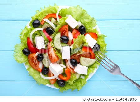 Fresh vegetable salad with fork on blue wooden background Fresh vegetable salad with fork on blue wooden background 114545996