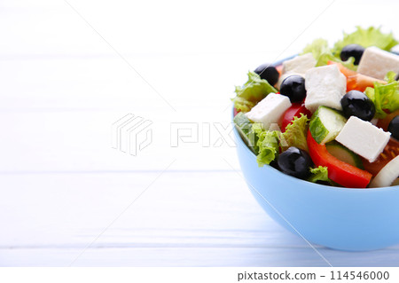 Fresh vegetable salad on bowl on white wooden background Fresh vegetable salad on bowl on white wooden background 114546000
