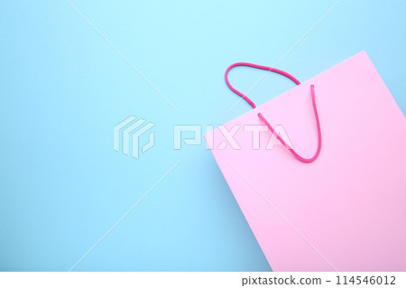 Pink paper shopping bag on blue background 114546012