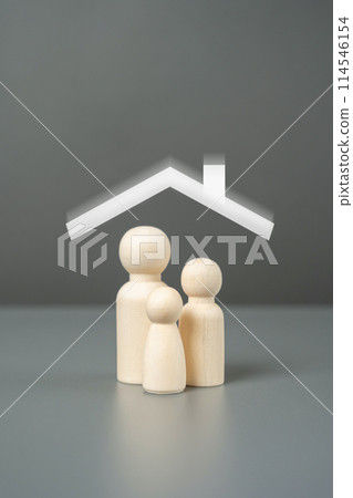 New home for a family. A family of figurines and a house roof overhead. Affordable housing concept. Buy an apartment with a mortgage. New home for a family. A family of figurines and a house roof overhead. Affordable housing concept. Buy an apartment with a mortgage. 114546154