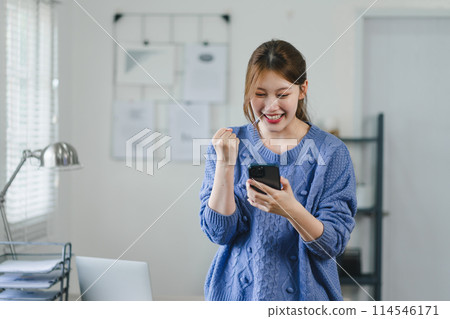 Excited woman celebrating good news on smartphone at home. 114546171