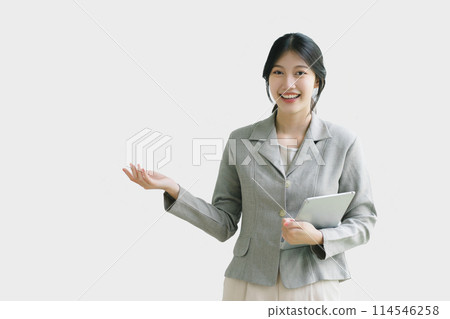 Professional businesswoman presenting with digital tablet against a white background. Professional businesswoman presenting with digital tablet against a white background. 114546258