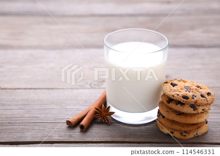 Glass of milk and chocolate cookies on grey background Glass of milk and chocolate cookies on grey background 114546331