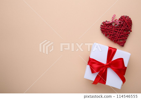 Valentines Day gift with red hearts on beige background Valentines Day gift with red hearts on beige background 114546555
