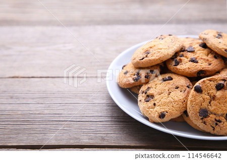 Chocolate chip cookies on plate on grey wooden background Chocolate chip cookies on plate on grey wooden background 114546642