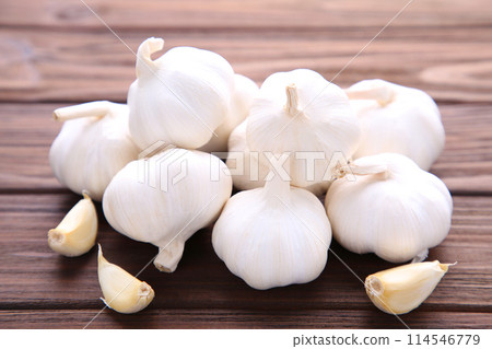 Fresh garlic on a brown wooden background Fresh garlic on a brown wooden background 114546779
