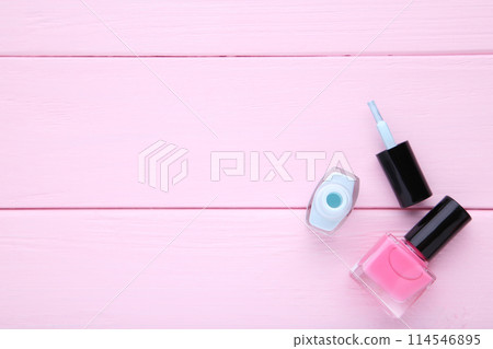 Pink and blue nail polishes on pink background Pink and blue nail polishes on pink background 114546895