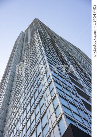 Upward view of modern skyscraper against blue sky Upward view of modern skyscraper against blue sky 114547402