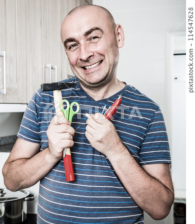Ordinary man posing with hammer in his hands Ordinary man posing with hammer in his hands 114547628