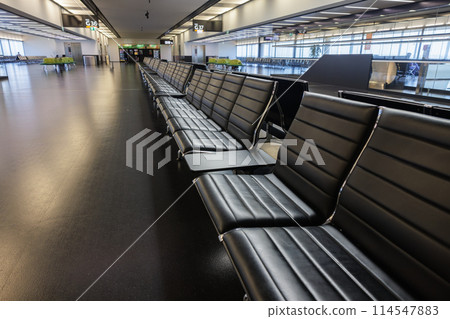 Empty airport terminal with black seats Empty airport terminal with black seats 114547883