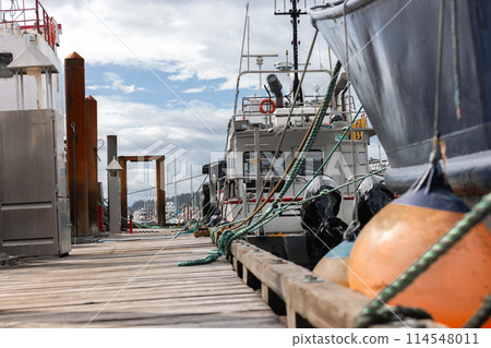 Wooden pier in industrial fishing harbor 114548011