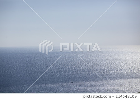 A small sailing boat sails on the sea surface of the Adriatic Sea. Balkans. View from above. Montenegro. Budva. Horizontal. A small sailing boat sails on the sea surface of the Adriatic Sea. Balkans. View from above. Montenegro. Budva. Horizontal. 114548109