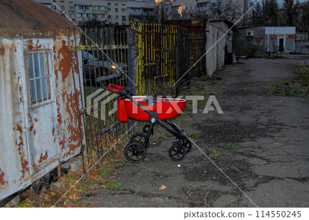 Baby stroller on a chain.An old, rusty, abandoned trailer.A hut with peeling paint  114550245