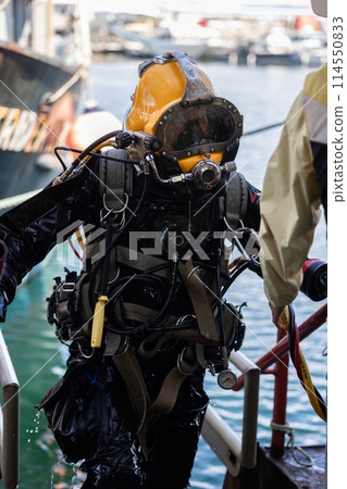Commercial diver exiting water at harbor 114550833