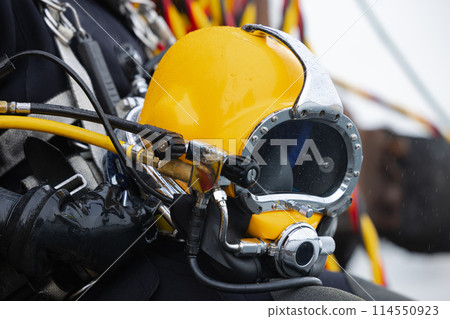 Closeup of diver holding commercial diving helmet 114550923