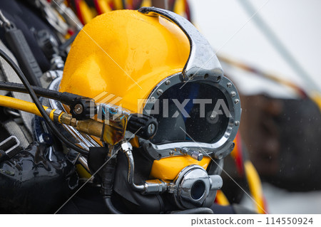 Closeup of diver holding commercial diving helmet 114550924