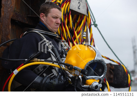 Closeup of diver holding commercial diving helmet Closeup of diver holding commercial diving helmet 114551131