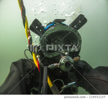 Commercial diver in helmet working underwater Commercial diver in helmet working underwater 114551137