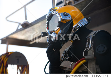 Commercial diver entering water in protective helmet Commercial diver entering water in protective helmet 114551151