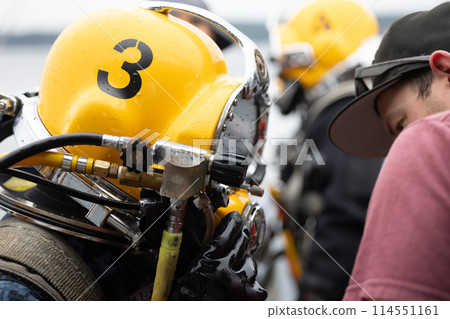 Diver assisted by tender before water entry 114551161