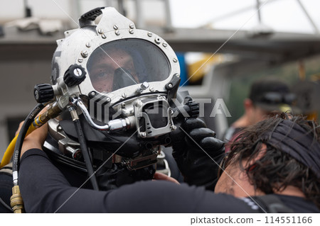 Diver assisted by tender before water entry 114551166