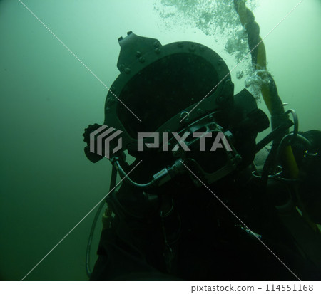 Closeup of commercial diver in helmet underwater 114551168
