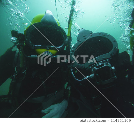 Closeup of commercial diver in helmet underwater Closeup of commercial diver in helmet underwater 114551169