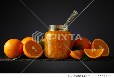 Orange jam in glass jar and fresh fruits on a black background. 114551542