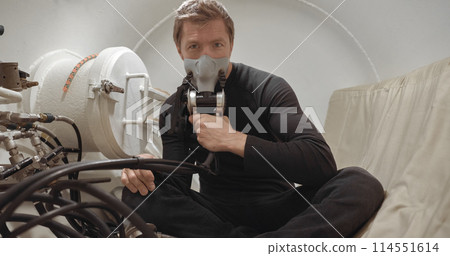 Military man receiving treatment in industrial hyperbaric chamber Military man receiving treatment in industrial hyperbaric chamber 114551614