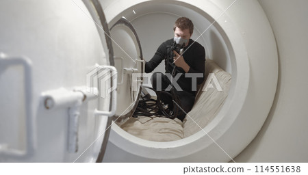Military man receiving treatment in industrial hyperbaric chamber Military man receiving treatment in industrial hyperbaric chamber 114551638
