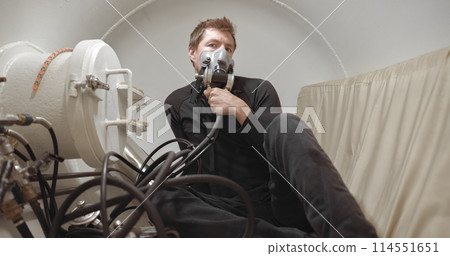 Military man receiving treatment in industrial hyperbaric chamber 114551651
