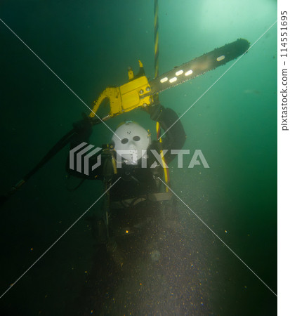Commercial diver cutting log underwater with chainsaw Commercial diver cutting log underwater with chainsaw 114551695
