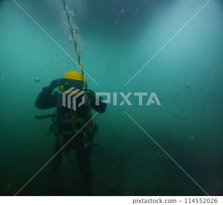 Commercial diver with vintage diving helmet 114552026