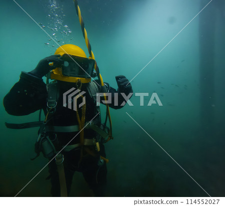 Commercial diver with vintage diving helmet 114552027