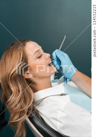 The doctor pretends to examine the condition of the teeth with a careful eye and uses modern technologies for the most accurate diagnosis. With high precision and knowledge, the doctor performs a 114552215